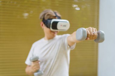 Aktif Asyalı sporcu halter ve sanal gerçeklik kullanarak online eğitim için sanal gerçeklik gözlüğü platformunu kullanarak ağırlık antrenmanı yapıyor. Sanal gerçekliğin ya da metazıt platform konseptinin icadı