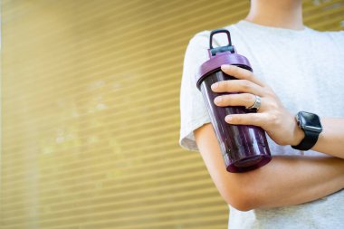 Aktif Asyalı sporcu açık hava koşusu ve antrenmandan sonra şişede su içiyor. Asyalı adam egzersize ara verdiğinde su içer. Sağlıklı bir adam kardiyo çalışması için çok çalışıyor..