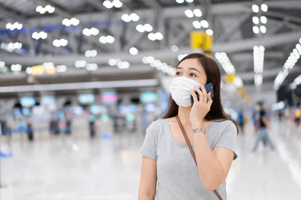 Gyönyörű Ázsiai Fiatal Védő Maszkot Beszél Egy Okostelefonon Repülőtéren Koronavírus — Stock Fotó