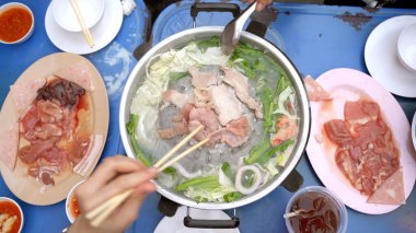 Tanınmayan bir grup insan geleneksel Tayland usulü domuz eti ve et barbeküsünü birlikte yemekten hoşlanıyor. Tayland usulü barbekü. Tayland BBQ tavası Moo Ka Ta Tayland 'da popüler bir ızgaradır..