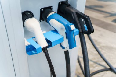 Modern elektrikli araç şarj istasyonunun ya da EV hızlı şarj istasyonunun fotoğrafı. Pil elektrikli araç ve prize takılı elektrikli araç için..