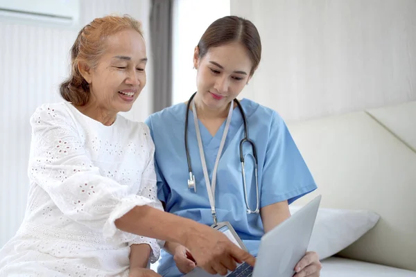 Female doctor comes to talk to elder patient in the hospital about the medical diagnosis. Doctor explaining a medical diagnostic result on laptop computer to old woman patient.