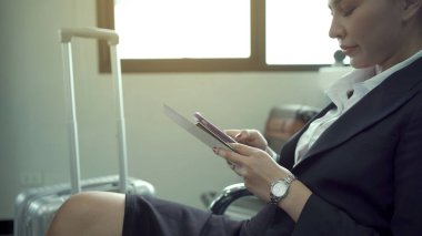 Happy Asian female business tourist portrait while using her smartphone for video call to her family before boarding time at the airport terminal. Woman tourist traveling by airplane.