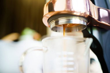 Barista küçük bir kahve dükkanında yüksek basınçlı espresso makinesi kullanarak kahve yapıyor. Kahve dükkanındaki kahve makineleri..