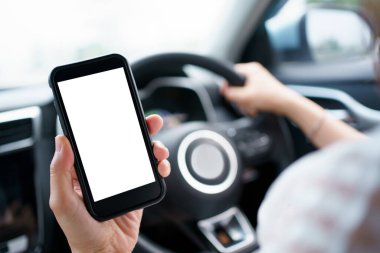 Empty screen smartphone isolated with clipping path. Unrecognizable careless woman using a smartphone while driving a car on highway. Dangerous driving behavior and careless people concept.
