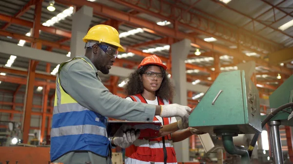 senior engineers inspecting the machines in the factory together, two Industrial engineers walking and inspecting the old machine in factory or warehouse.