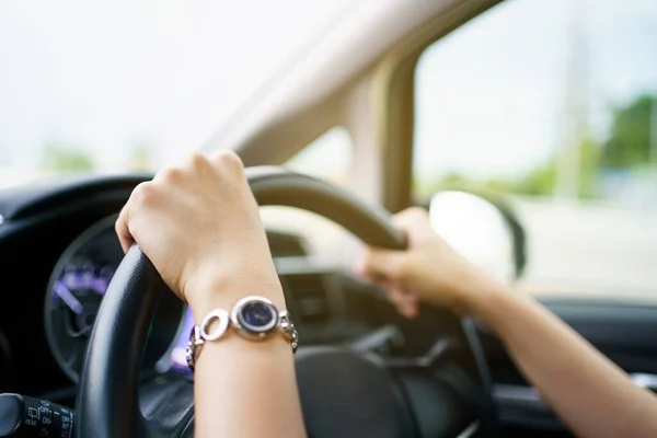 Happy Asian woman driving the electric vehicle - EV car smiling and showing her thumb up to the camera, happy and safety driving concept. Woman driving modern EV car and smiles to camera.