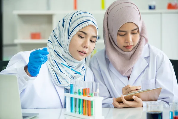 Asian young Muslim scientist testing the chemical experiment in laboratory. Professional scientific pharmaceutical chemist investigating and making experiment in laboratory.