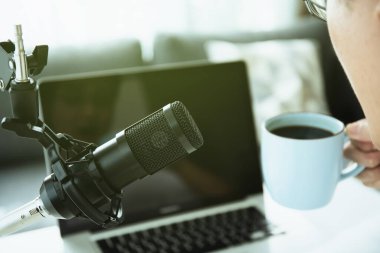 Ev podcast 'i yapan tanınmayan Asyalı genç adam ya da online radyo canlı yayını yapan ve dizüstü bilgisayar ya da defter ekranına bakan. Canlı yayın ve podcast performansı.