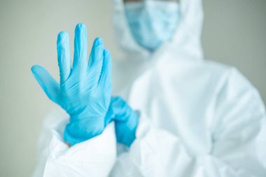 Tanımlanamayan uzman doktor hastanede çalışmadan önce tıbbi bir PPE giysisi giyer. Koronavirüs için kişisel koruma ekipmanı veya PPE giysisi kullanımı - COVID-19 salgını.