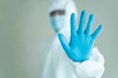 Tanımlanamayan uzman doktor hastanede çalışmadan önce tıbbi bir PPE giysisi giyer. Koronavirüs için kişisel koruma ekipmanı veya PPE giysisi kullanımı - COVID-19 salgını.