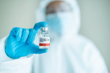 Koronavirüs SARS 2019-nCoV ya da COVID-19 aşısı gösteren tıbbi bir PPE giysisi içinde tanınmayan bir uzman doktor. Koronavirüs için kişisel koruma ekipmanı veya PPE giysisi kullanımı - COVID-19 salgını.