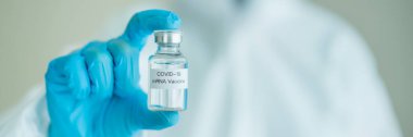 Koronavirüs SARS 2019-nCoV ya da COVID-19 mRNA aşısı gösteren tıbbi bir PPE giysisi içinde tanınmayan bir uzman doktor. Koronavirüs için kişisel koruma ekipmanı veya PPE giysisi kullanımı - COVID-19 salgını.