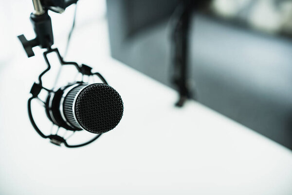 Профессиональный конденсаторный микрофон на держателе микрофона закрывается копипространством. Концепция живого подкаста и стриминга дома.