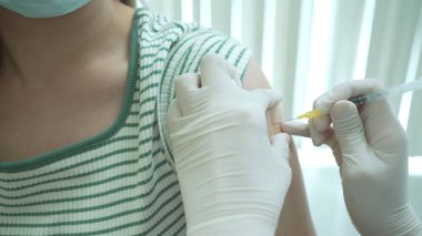 Doktor, hastanın sol koluna bir doz aşı hazırlıyor. Kopyalama alanı yakın. Sağlık ve tıbbi hizmet kavramı. COVID-19 veya koronavirüs aşıyı tedavi eder..