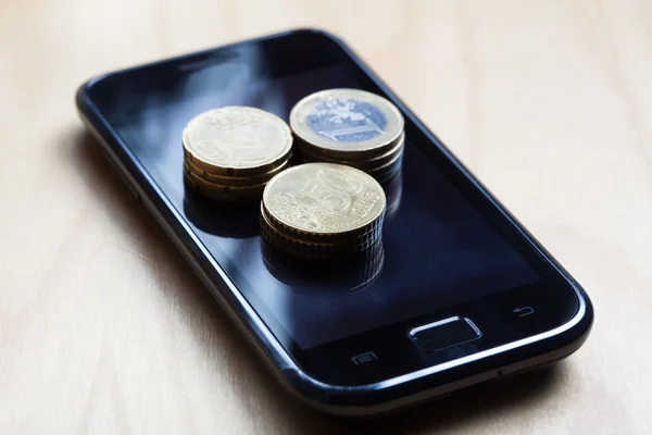 Moedas de euro em cima do telemóvel — Fotografia de Stock