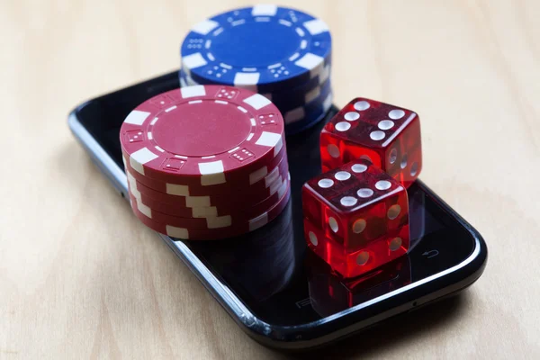 Poker Chips and Dices on top of cell phone — Stock Photo, Image