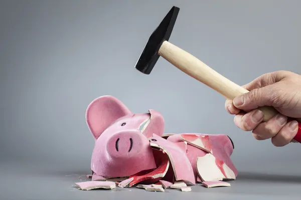 Robbing piggy bank with hammer — Stock Photo, Image