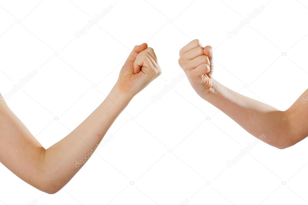 Two kids' fists pointing against each other, isolated white
