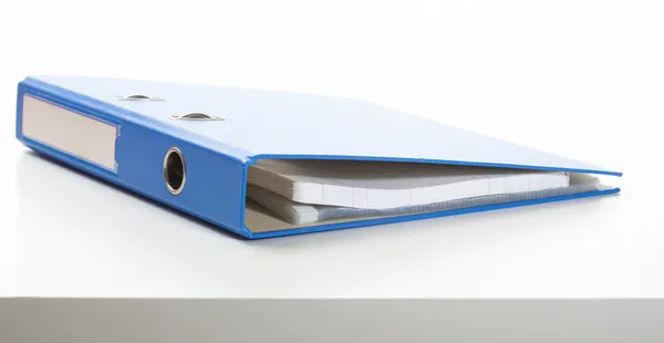 Blauwe ring binder op een bureau — Stockfoto