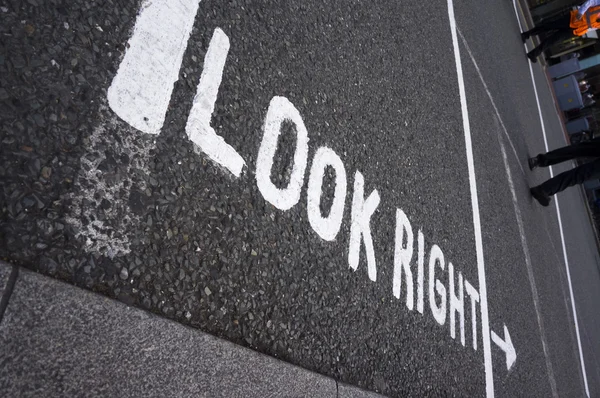 Waarschuwingsbericht "kijk rechts" op voetpad kruising straat — Stockfoto
