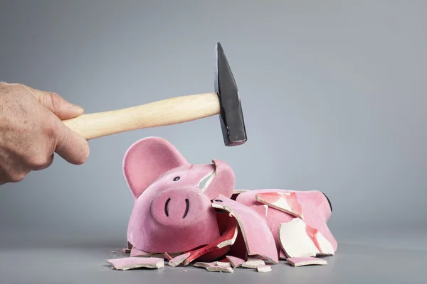 Robbing piggy bank with hammer — Stock Photo, Image