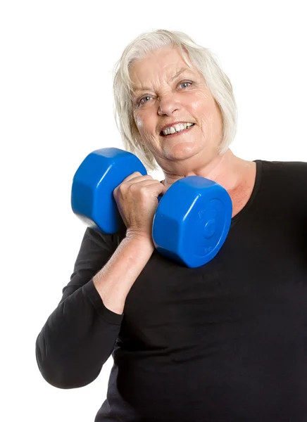 Mujer mayor deportiva posando con mancuerna — Foto de Stock