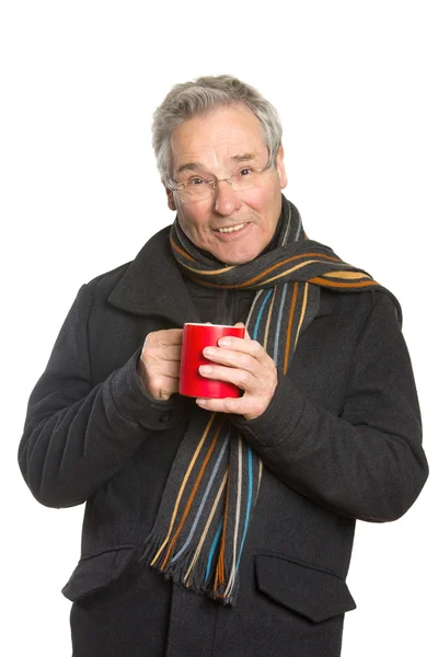 Senior in Winterkleidung hält Pokal in der Hand — Stockfoto