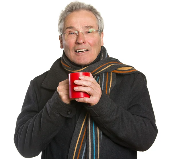 Senior man in winter clothing holding cup — Stock Photo, Image