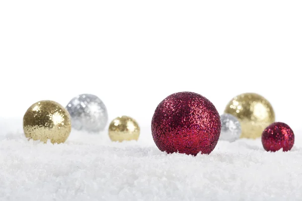 Gold, red, silver balls on snow underground — Stock Photo, Image