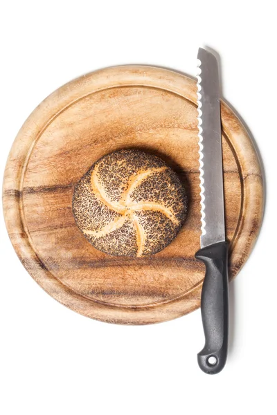 Poppy seed bread roll (Mohnbroetchen) on cutting board with knif — Stock Photo, Image
