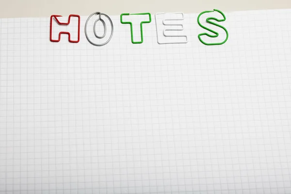 Notas soletradas com letras de clipe de papel no bloco de notas — Fotografia de Stock