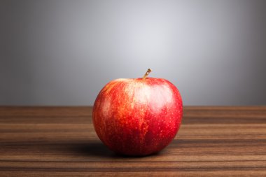 Tablo, gri arka plan üzerinde kırmızı elma