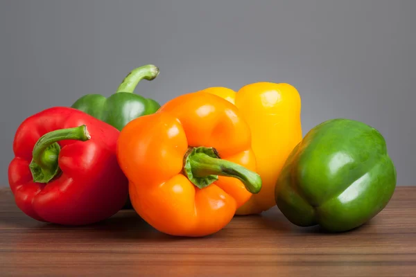 Raw peppers, multiple colors, on table Royalty Free Stock Images