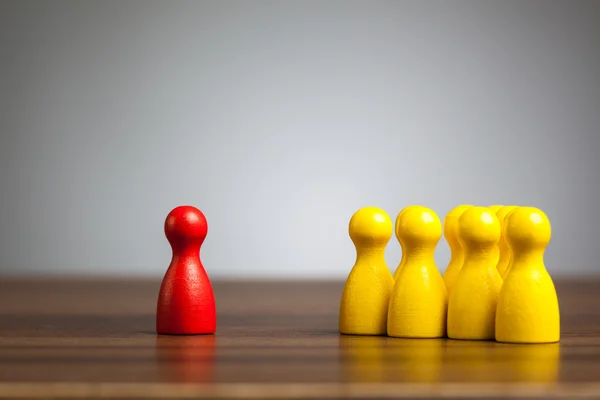 Red pawn figure against united yellow, isolation, confrontation, — Stock Photo, Image