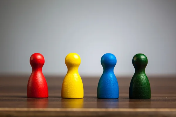 Cuatro figuras de peón, concepto de equipo, mesa, fondo gris — Foto de Stock