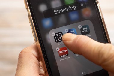 BERLİN, GERMANY - 25 HAZİRAN 2022: Parmak, 2022 'deki sert fiyat artışından sonra bir iPhone X' ten DAZN spor yayın uygulamasını kaldırıyor