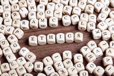 Word Ethis in letters on cube dices on table.