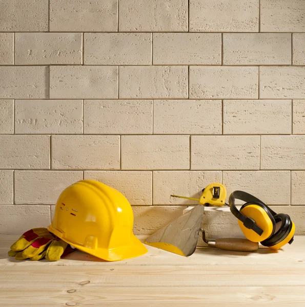 Brick background, helmet and trowel — Stock Photo, Image