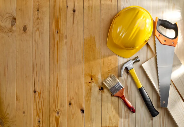 Wood floor with a brush, tools and helmet — Stock Photo, Image