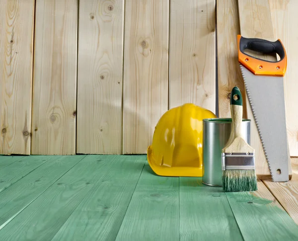 Suelo de madera verde con un cepillo, sierra y casco — Foto de Stock