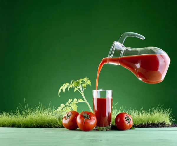 Çim zemin üzerine taze domates suyu — Stok fotoğraf