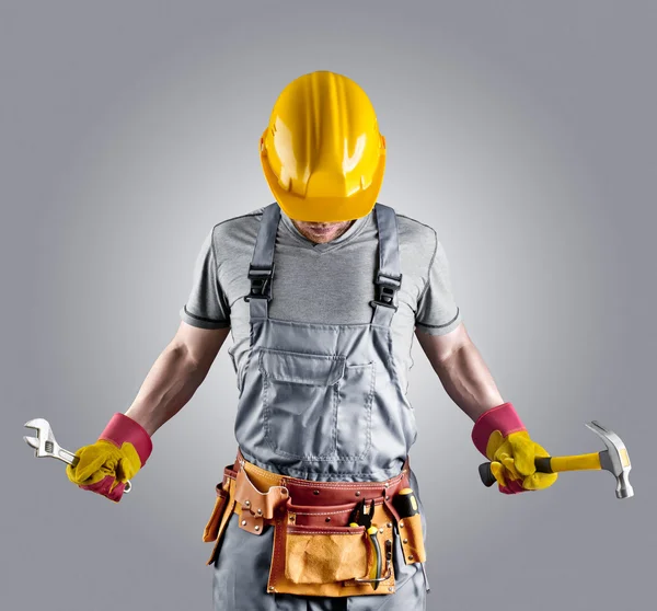 Constructor en un casco con un martillo y una llave — Foto de Stock