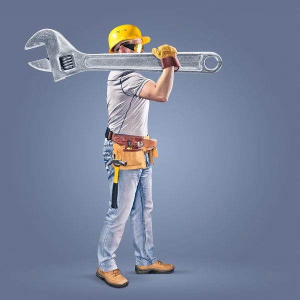 Construction worker with a tool belt and a wrench — Stock Photo, Image