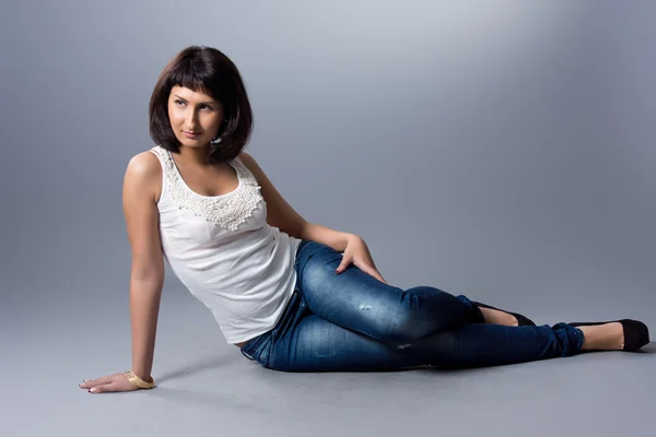 Vacker flicka i jeans och en vit blus — Stockfoto