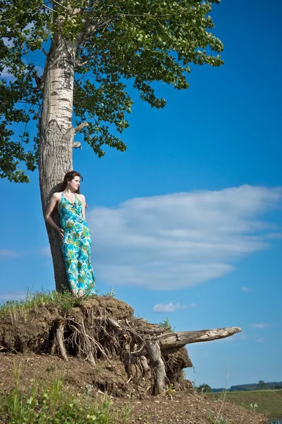 Vacker flicka på en bakgrund av blå himmel — Stockfoto