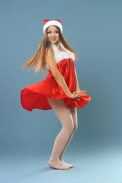Kırmızı elbise ve Noel Baba şapkalı kız — Stok fotoğraf