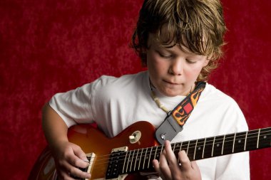 Çocuk rock yıldızı elektro gitar çalıyor.
