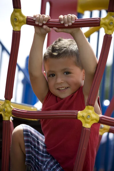 Niño hispano balanceándose de bares de monos —  Fotos de Stock