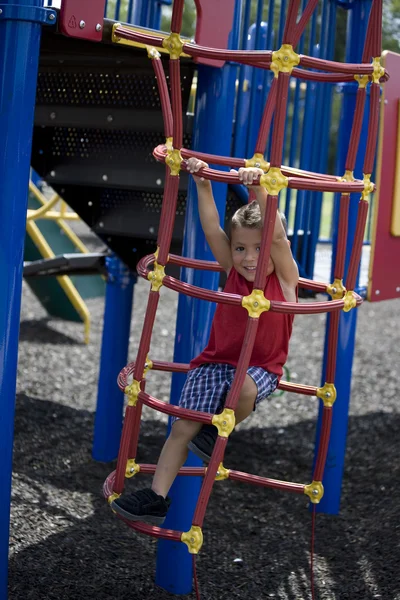 Niño hispano balanceándose de bares de monos —  Fotos de Stock